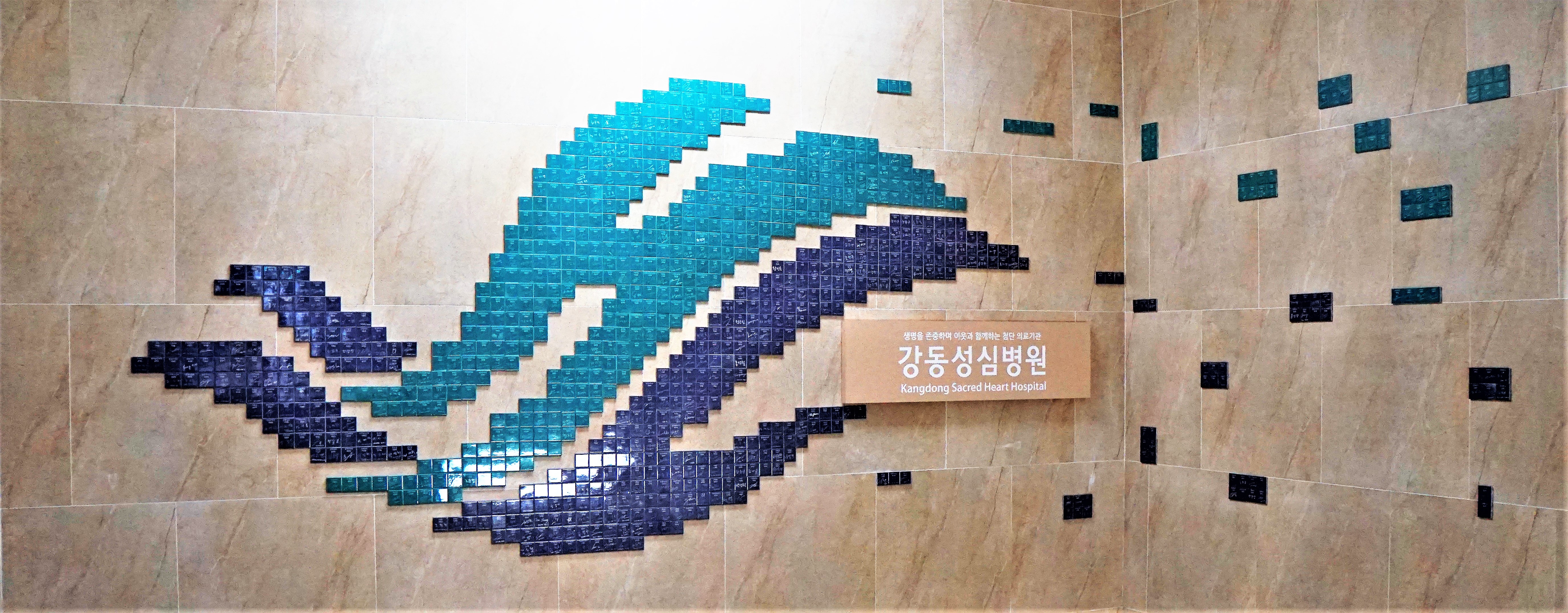 본관 지하 계단에 있는 명의료진 명찰로 만든 로고 설치물 